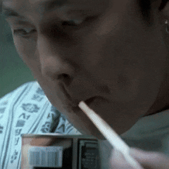 a man is drinking from a can with a straw