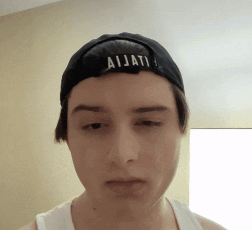 a young man wearing a black hat with ajjati written on it