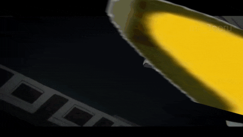 a piece of paper is flying through the air in front of a yellow object