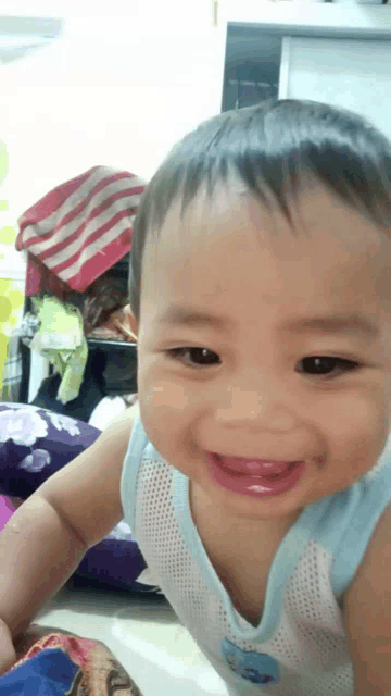 a baby is smiling and wearing a shirt that says ' disney ' on it