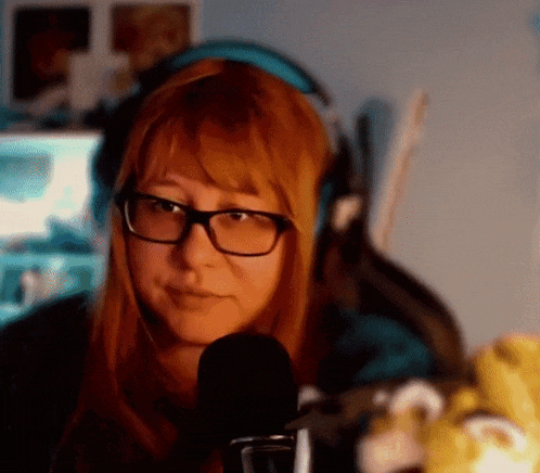 a woman wearing glasses and headphones is sitting in front of a microphone