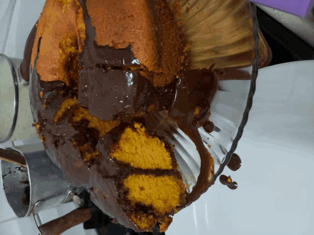 a cake with a slice taken out of it covered in chocolate