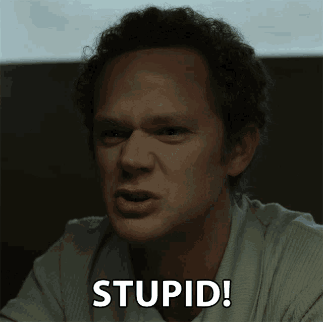 a close up of a man 's face with the words stupid written below it