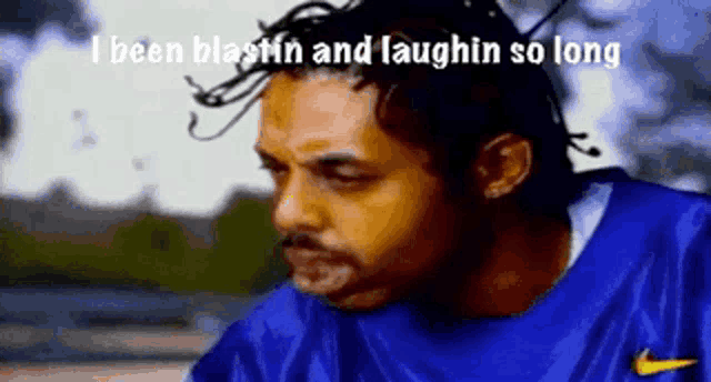 a man wearing a blue nike shirt is laughing .