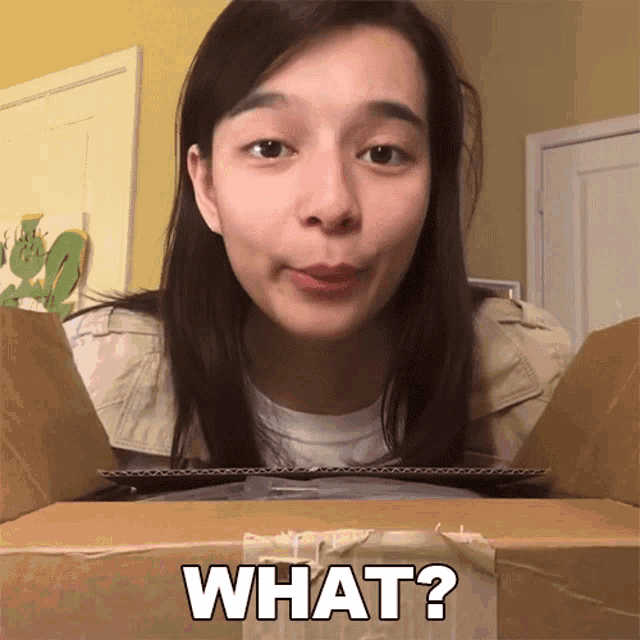 a woman looking into a cardboard box with the words what written on it