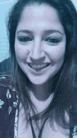 a close up of a woman 's face smiling in a black and white photo .