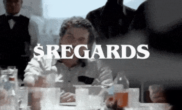 a man sitting at a table with a sign that says sregards
