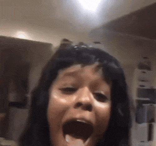a close up of a woman with her mouth open