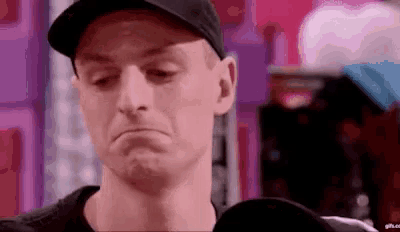 a close up of a man wearing a hat making a sad face .