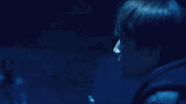 a person holding a flashlight with a blue light coming out of it