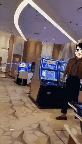 a man standing in front of a row of slot machines including one that says joker 32