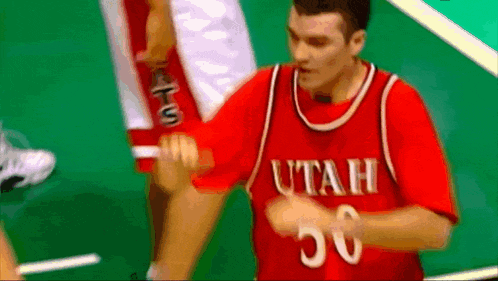 a man in a red utah jersey is giving a high five
