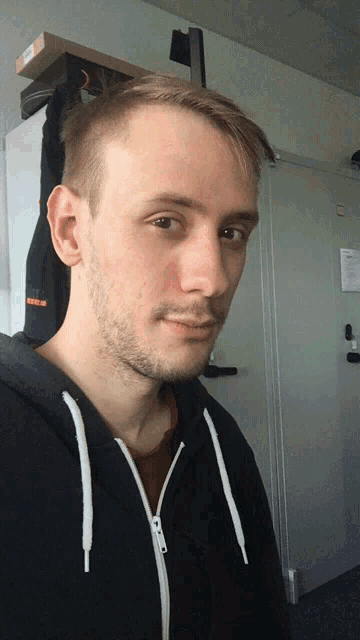 a man wearing a black hoodie with white laces