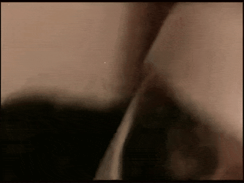 a close up of a person 's face in a dark room with a blurred background