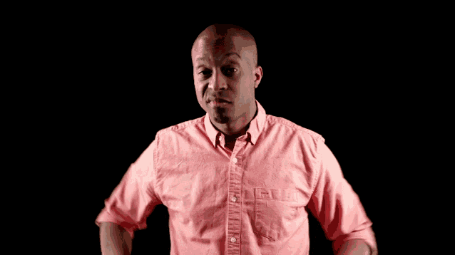 a man wearing a pink shirt with his hands on his hips