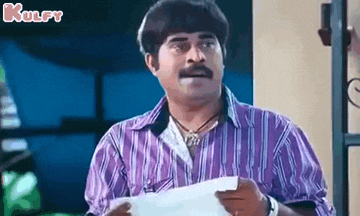 a man in a purple striped shirt is holding a piece of paper .