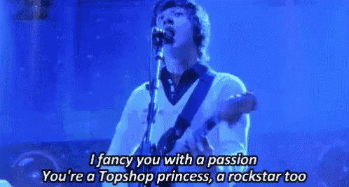 a man is singing into a microphone while playing a guitar on a stage .