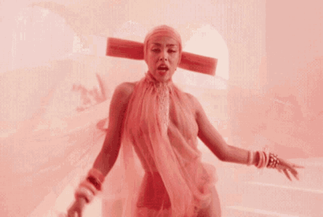 a woman is wearing a pink dress and a pink headband