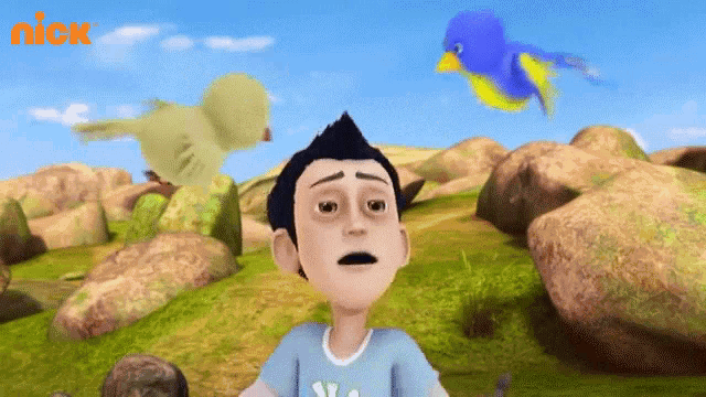 a boy in a blue shirt is looking up at a bird with the nick logo behind him