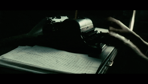 a stack of papers on a table with a person walking in the background