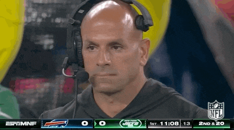 a man wearing a headset is watching a football game on espn