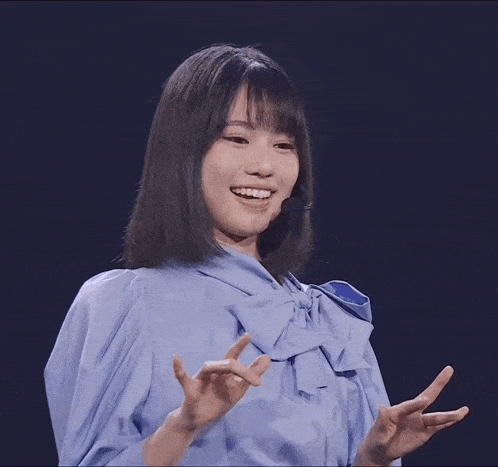 a woman in a blue shirt with a bow on it