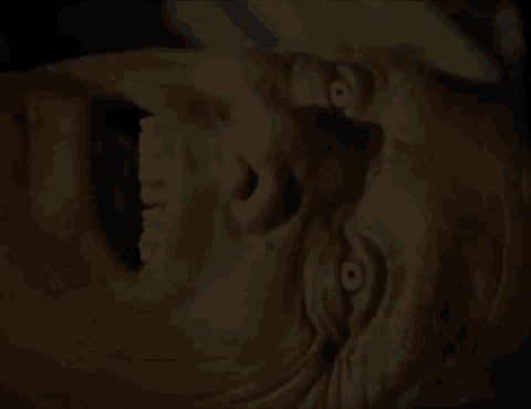 a close up of a person 's face with glowing eyes and a mouth open .