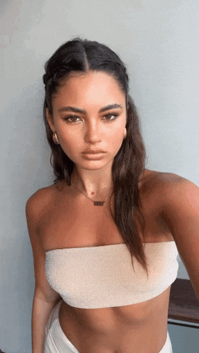 a woman is wearing a strapless top and a necklace that says ' i love you '