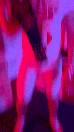 a blurry picture of a person dancing with a purple light behind them