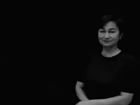 a woman in a black shirt stands in front of a black background with the words очень смешно written on it