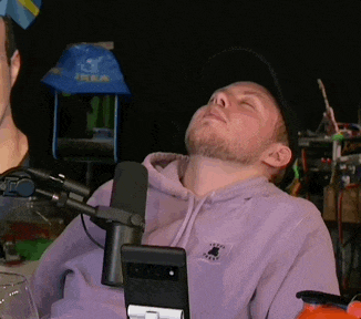 a man in a purple hoodie is sitting in front of a microphone