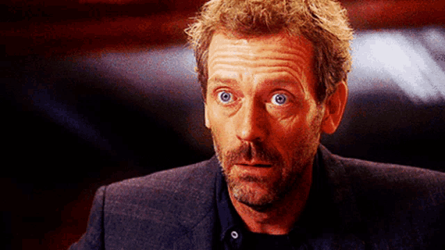 a man with blue eyes is wearing a suit