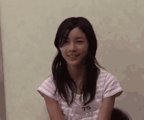 a young woman is smiling while sitting in a chair .