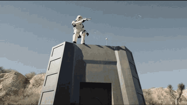 a storm trooper is standing on top of a building with a gun