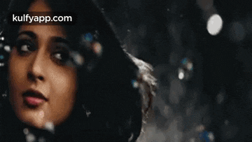a close up of a woman 's face with bubbles in her hair .