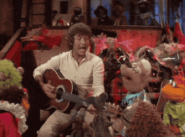 a man is playing a guitar in front of a group of stuffed animals