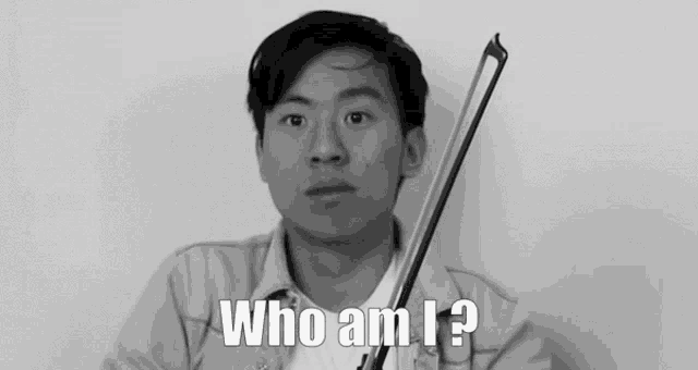 a man holding a violin with the words who am i behind him