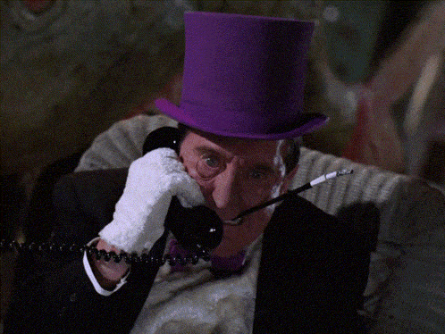 a man in a purple top hat is talking on a telephone