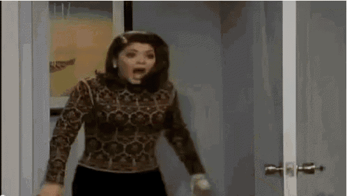 a woman is standing in a doorway with her mouth open and screaming .