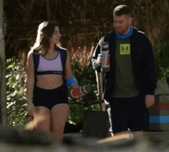 a man wearing a green under armour shirt talks to a woman