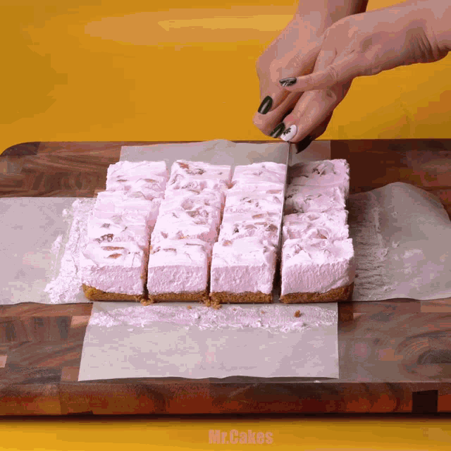 a person is cutting a piece of cake on a cutting board with mr.cakes written on the bottom