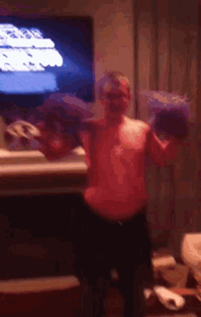 a man without a shirt is standing in front of a television holding a purple bag