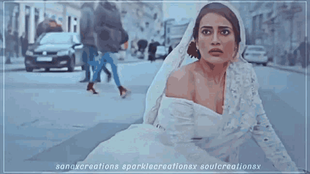 a woman in a wedding dress is standing on a street .