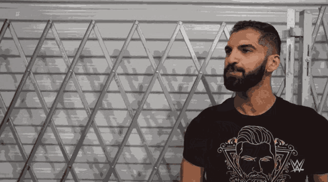 a man with a beard is wearing a black t-shirt that says wwe on it
