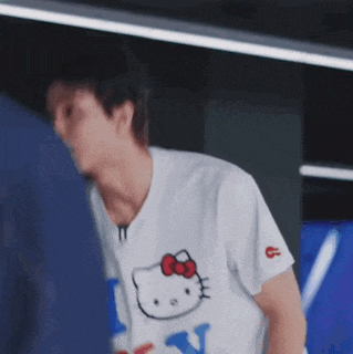 a man wearing a hello kitty t-shirt is standing next to another man .