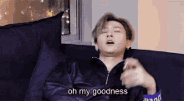a man is laying on a couch with his eyes closed and says oh my goodness .