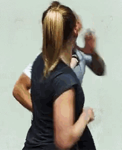a woman in a ponytail is standing next to a man