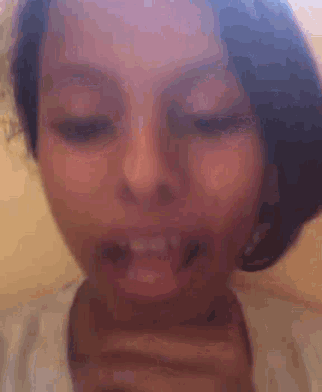 a close up of a woman 's face with her mouth open and her teeth showing .