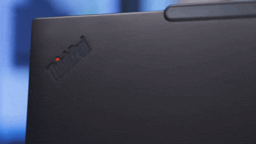 a black thinkpad laptop with a red light on the back