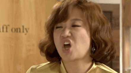 a woman with curly hair is making a funny face with her mouth open .